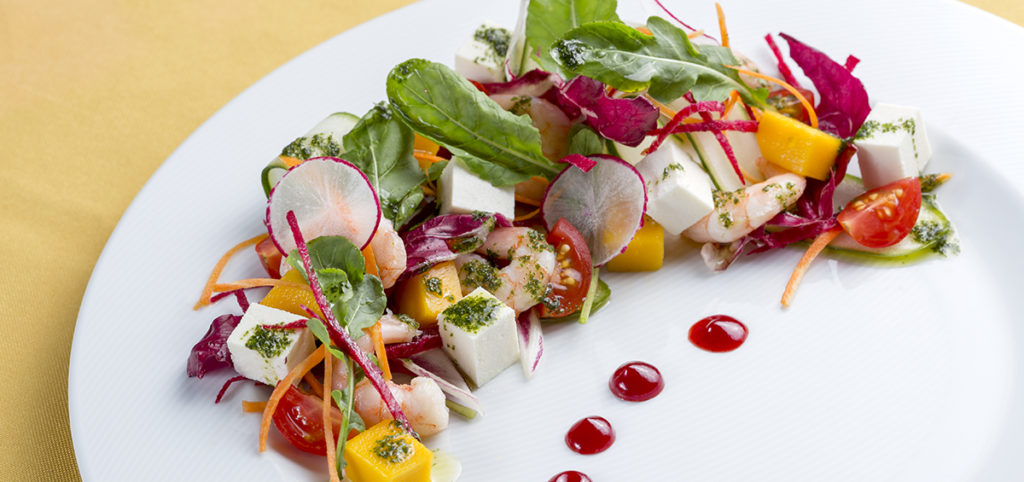 Salada Visconde de Suassuna, camarões cozidos, fios de legumes, queijo coalho e quiabo frito, tudo regado ao azeite de coentro e redução de acerola.