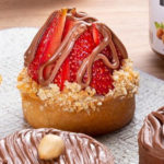 Uma foto que mostra uma variedade de docinhos feitos com Nutella, o creme de avelã e chocolate. Todos com uma aparência deliciosa e decorados com Nutella, morangos, avelãs, chocolate. A foto tem um fundo branco e uma iluminação suave, que destaca as cores e as texturas dos doces. A foto transmite uma sensação de doçura, tentação e sabor.