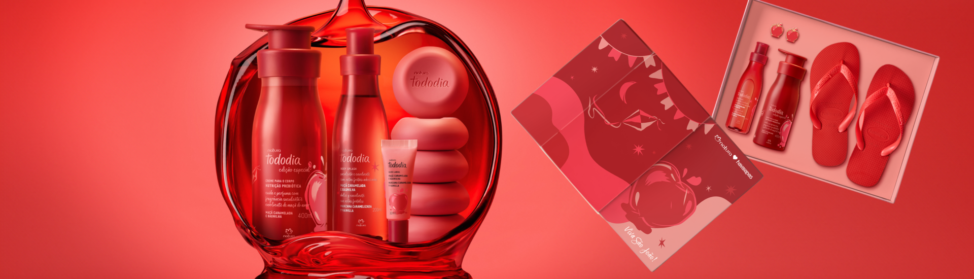 Imagem da linha Natura Tododia Maçã Caramelada e Baunilha com hidratante corporal 400ml, body splash 200ml, gloss labial, sabonetes em barra e caixa do kit exclusivo da collab com Havaianas, contendo chinelo vermelho e pin em formato de maçã do amor. Embalagens em tons vermelhos e dourados, inspiradas na maçã do amor, fragrância gourmand doce com notas de maçã vermelha, baunilha e caramelo. Cosméticos veganos para autocuidado e beleza com aroma de sobremesa, lançados para o período junino.